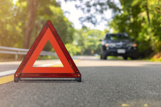 Red triangle, red emergency stop sign, red emergency symbol and black car stop and park on road.