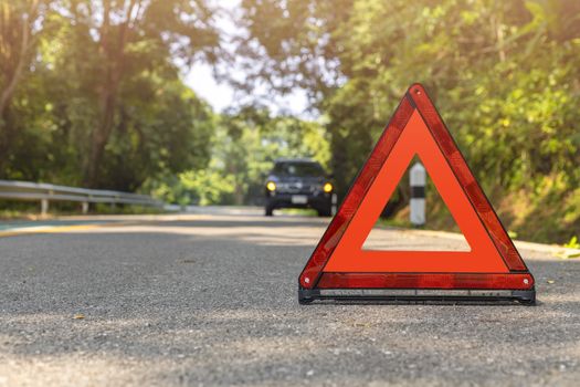 Red triangle, red emergency stop sign, red emergency symbol and black car stop and park on road.