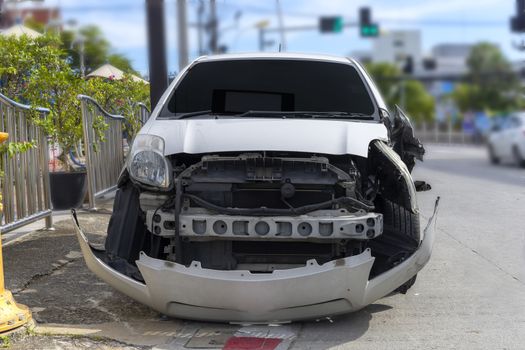 Front of white color car big damaged and broken by accident on city street parking can not drive any more. With copy space for text or design