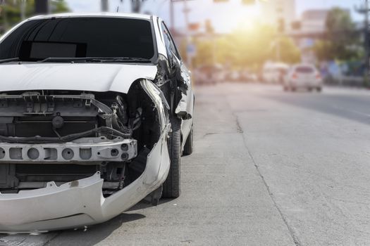 Front of white color car big damaged and broken by accident on city street parking can not drive any more. With copy space for text or design