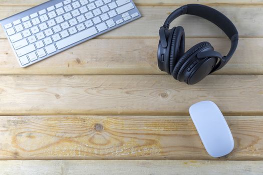 Top view Headphones and laptop on wood table. With copy space for text or design. Technology concept.