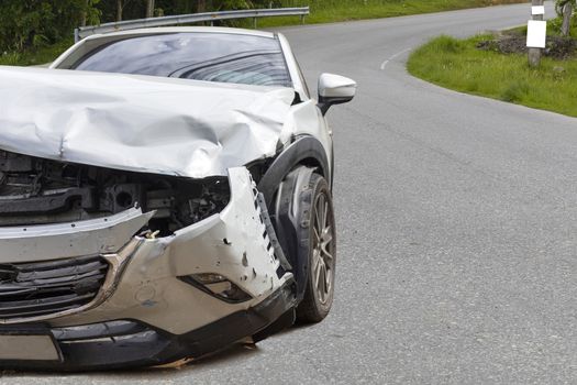 Front of light gray car big damaged and broken by accident on city street parking can not drive any more. With copy space for text or design