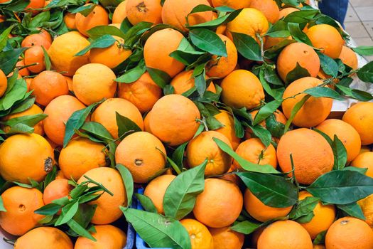 Pile of oranges with leaves for sale at a market