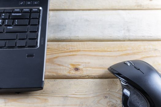 Office concept. Mouse and laptop on wood table. With copy space for text or design.