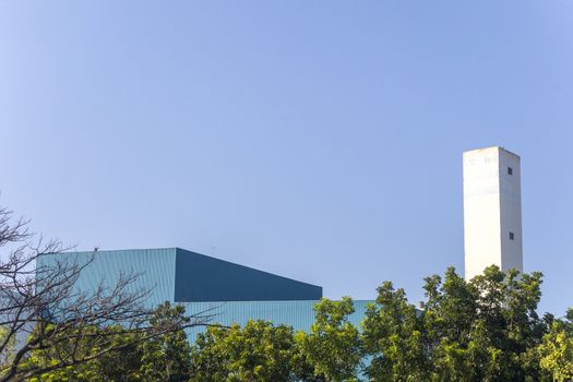 top of factory building shot form garden with clear sky background. With copy space for text or design