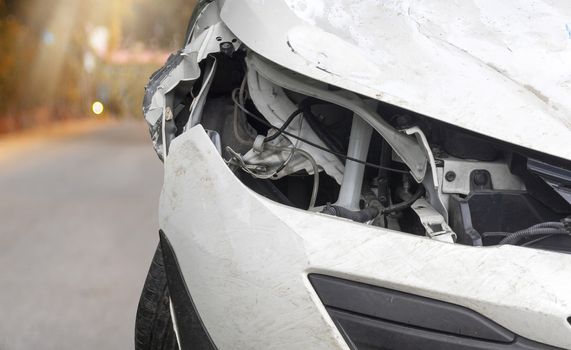 Close up head light of  white color car have damaged and broken by accident on road parking can not dirve any more. 