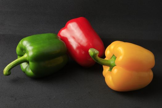 Fresh Green, yellow, red bell pepper. Sweet pepper. Giant pepper on black background. 
