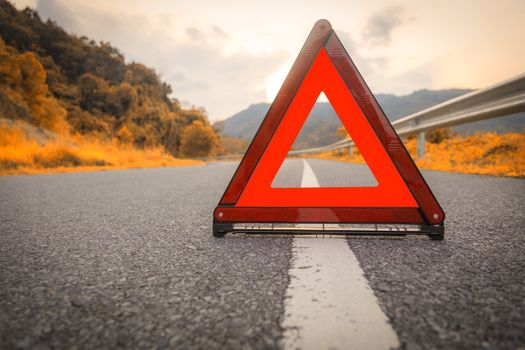 Autumn road Red triangle, red emergency stop sign, red emergency symbol on road. With copy space for text or design
