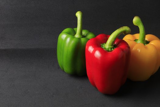Fresh Green, yellow, red bell pepper. Sweet pepper. Giant pepper on black background. 