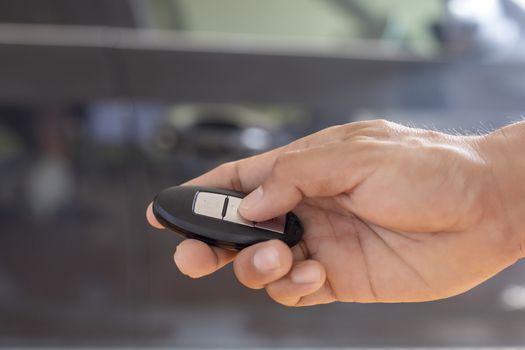 Hand man hode car remote for open the car. Soft focus and focus selective remote.