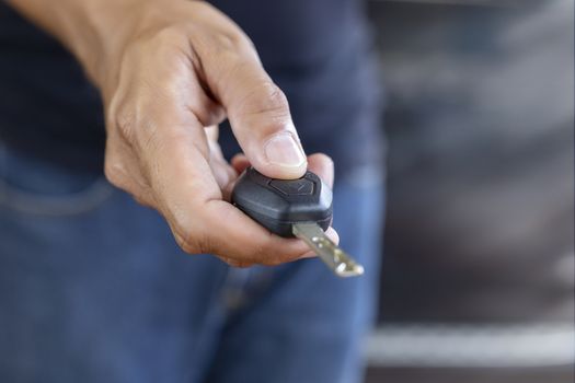 Hand man hode car remote for open the car. Soft focus and focus selective remote.