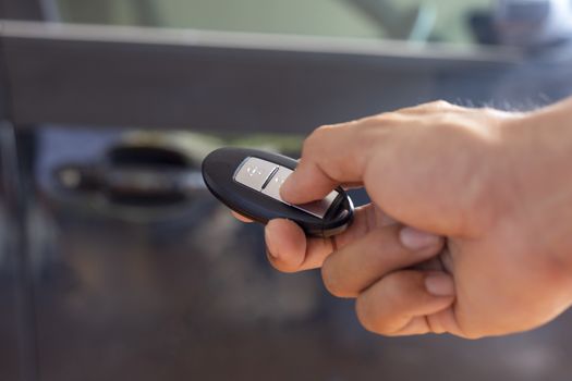 Hand man hode car remote for open the car. Soft focus and focus selective remote.