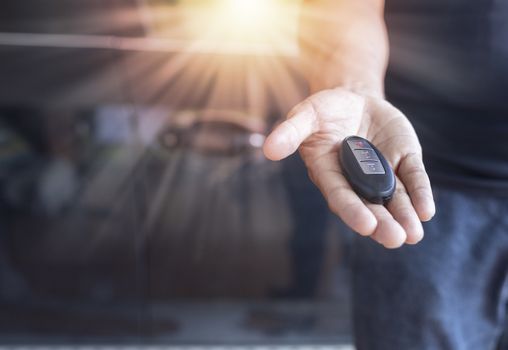 Car key remote on hand. Hand man giving a car remote. 