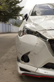Front of white color car big damaged and broken by accident on road parking can not drive any more. With copy space for text or design