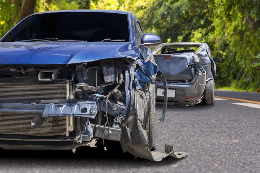 Front of blue color car crash with black car have big damaged and broken by accident on road can not drive any more.