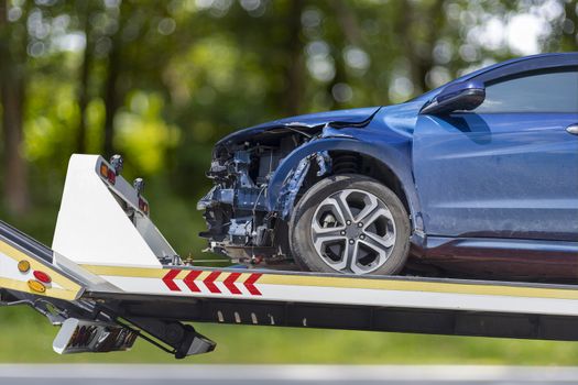 accident Car Slide on truck for move. Blue car have damage by accident on road take with slide truck move . 