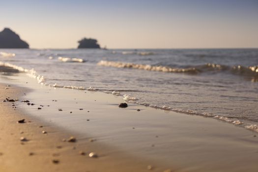 Soft wave from sea come to wet sand beach with blur clear sky background. With copy space for text or design