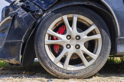Close up tire after front black car damaged and broken by accident on road