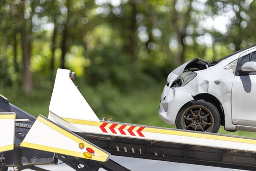accident Car Slide on truck for move. White car have damage by accident on road take with slide truck move .