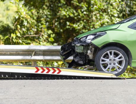 accident Car Slide on  truck for move. Green car have damage by accident on road take with slide truck move . I