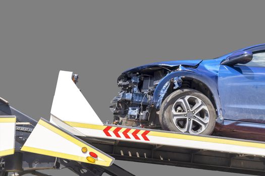 accident Car Slide on truck for move. Blue car have damage by accident on road take with slide truck move . Isolate on gray background .