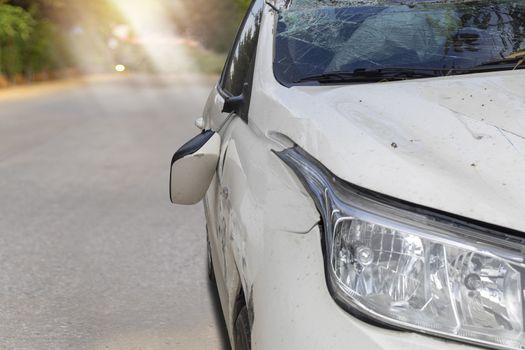 Front of white color car big damaged and broken by accident on road parking can not drive any more. With copy space for text or design