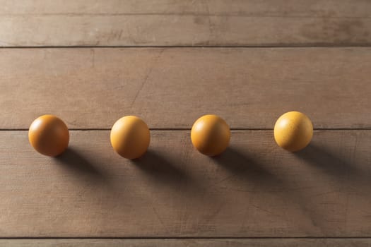 Top view 4 eggs on wood table with copy space. social distancing concept.