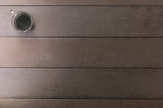 Top view black coffee cup on old wood table. coffee in handle cup with copy space. Hot black coffee with smoke.