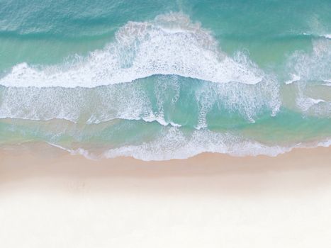 Aerial view top view Beautiful topical beach with white sand coconut palm trees and sea. Top view empty and clean beach. Waves crashing empty beach from above. With copy space.