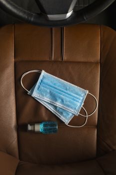 Top view Medical mask Alcohol Hand sanitizer gel on The car seat .