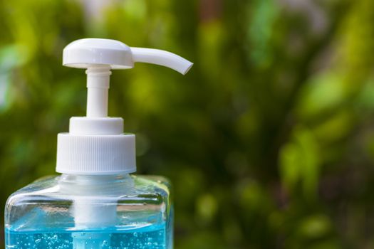 Close up pump of Blue alcohols gel bottle on nature background.