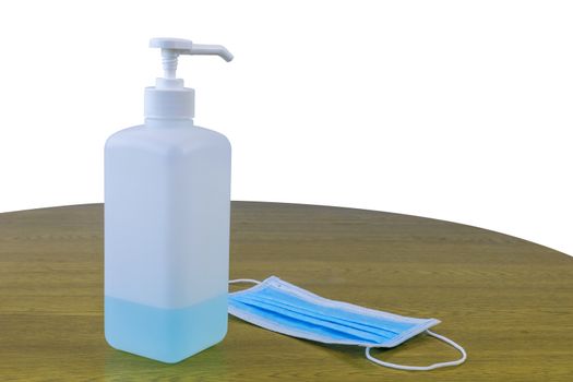 Coronavirus Covid-19 concept face mask with alcohol sanitizer gel hand wash on wood table and white background.