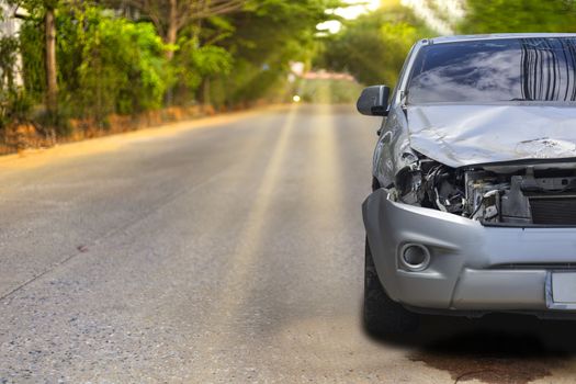 Front of light gray color car with pick up have big damaged and broken by accident on road in morning time can not drive any more park for wait insurance officer. With copy space for text or design