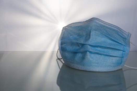 Medical protective mask on table with sunray background.