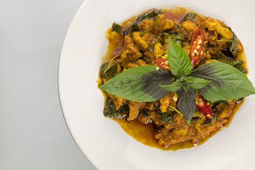 Top view stir fried chicken and curry paste on white plate with copyspace for text or design.