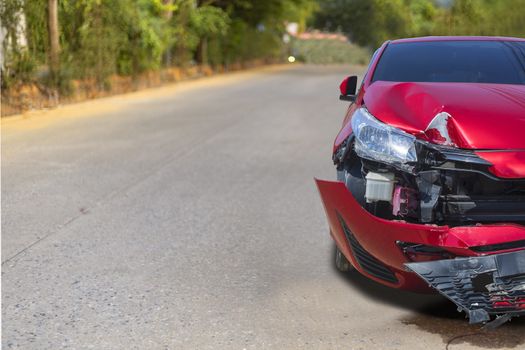 Front of light red color car have big damaged and broken by accident on road in morning time can not drive any more park for wait insurance officer. With copy space for text or design