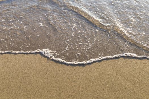 Top view Soft wave from sea come to wet sand beach background. With copy space for text or design