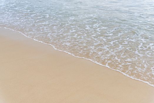 Top view Soft wave from sea come to wet sand beach background. With copy space for text or design
