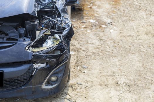 Close up front of black color car damaged and broken by accident on road.
