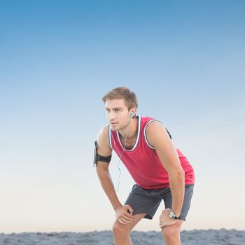 Fit man taking break against horizon over the sand