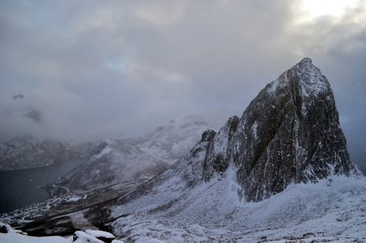 Beautiful rock covers with snowy clouds in minutes on Senja region