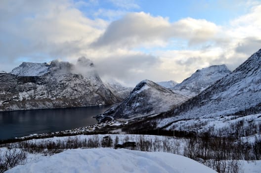 Marvelous snowy mountains are covered with clouds 