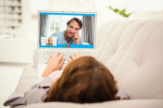 Closeup of beautiful woman smiling at home against woman using laptop while lying on sofa