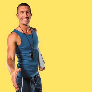 Happy personal trainer giving handshake against yellow background