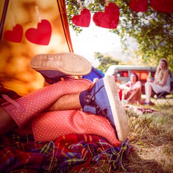 Young couple making out in tent against hearts hanging on a line