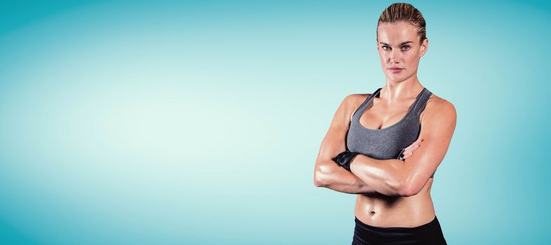 Muscular woman with arms crossed  against blue vignette background