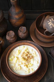 Milk traditional soup of Belarus with noodles and dough in a ceramic bowl on dark rustic table