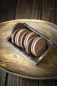 Dark cookie of two chocolate wafers with a sweet creme filling in between, vertical image