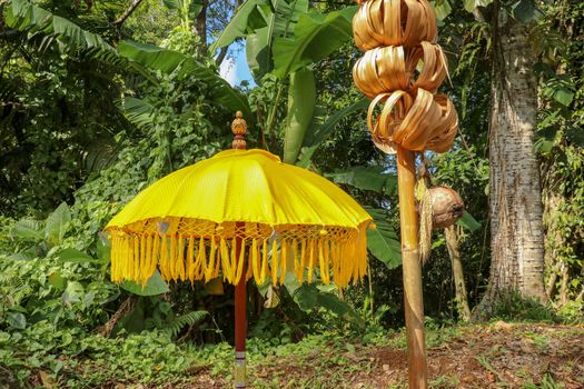 Decoration of Hindu temple complex Batukaru on Bali island in Indonesia. Yellow and white decorative umbrellas line the path for believing visitors. Colorful fabric umbrellas with decorative fringes.