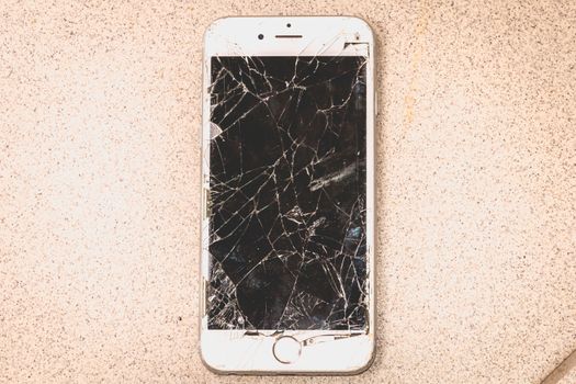 Paris, FRANCE - August 26, 2017: white iPhone 6S developed by the company Apple Inc., whose screen is broken after a violent fall